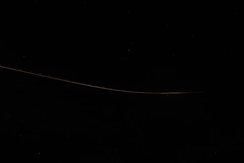 Plane flying across the sky at night