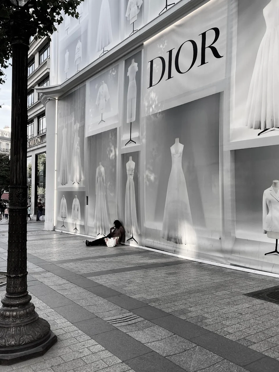 Homeless person in front of the Dior store in Paris today