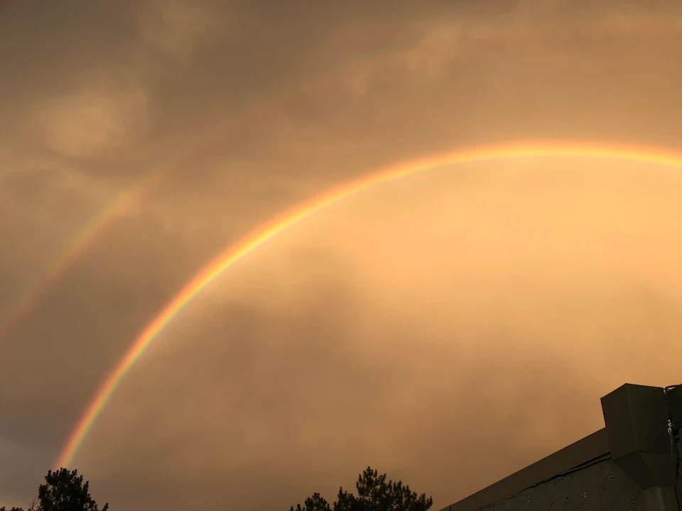 Double rainbow lit up by the sunset